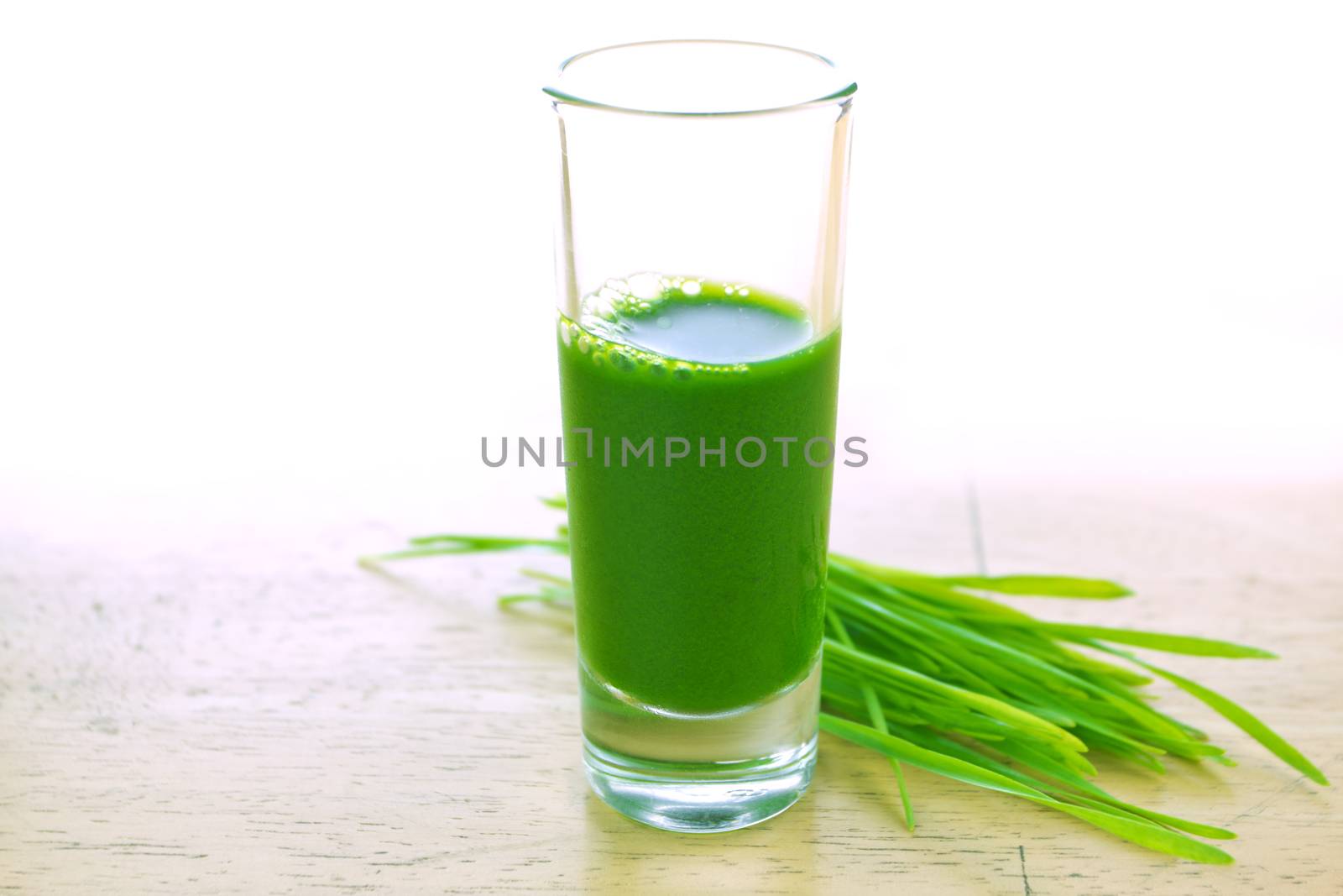 Wheathgrass juice on wood background