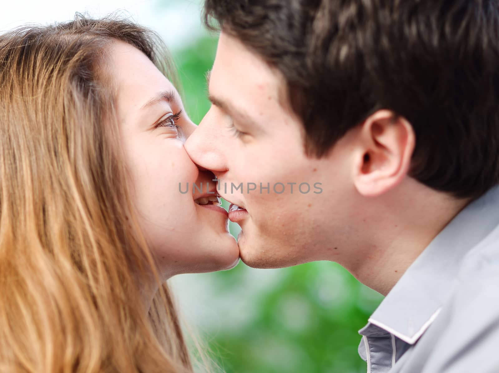 Attractive couple of lovers kissing itself lovingly on a sofa