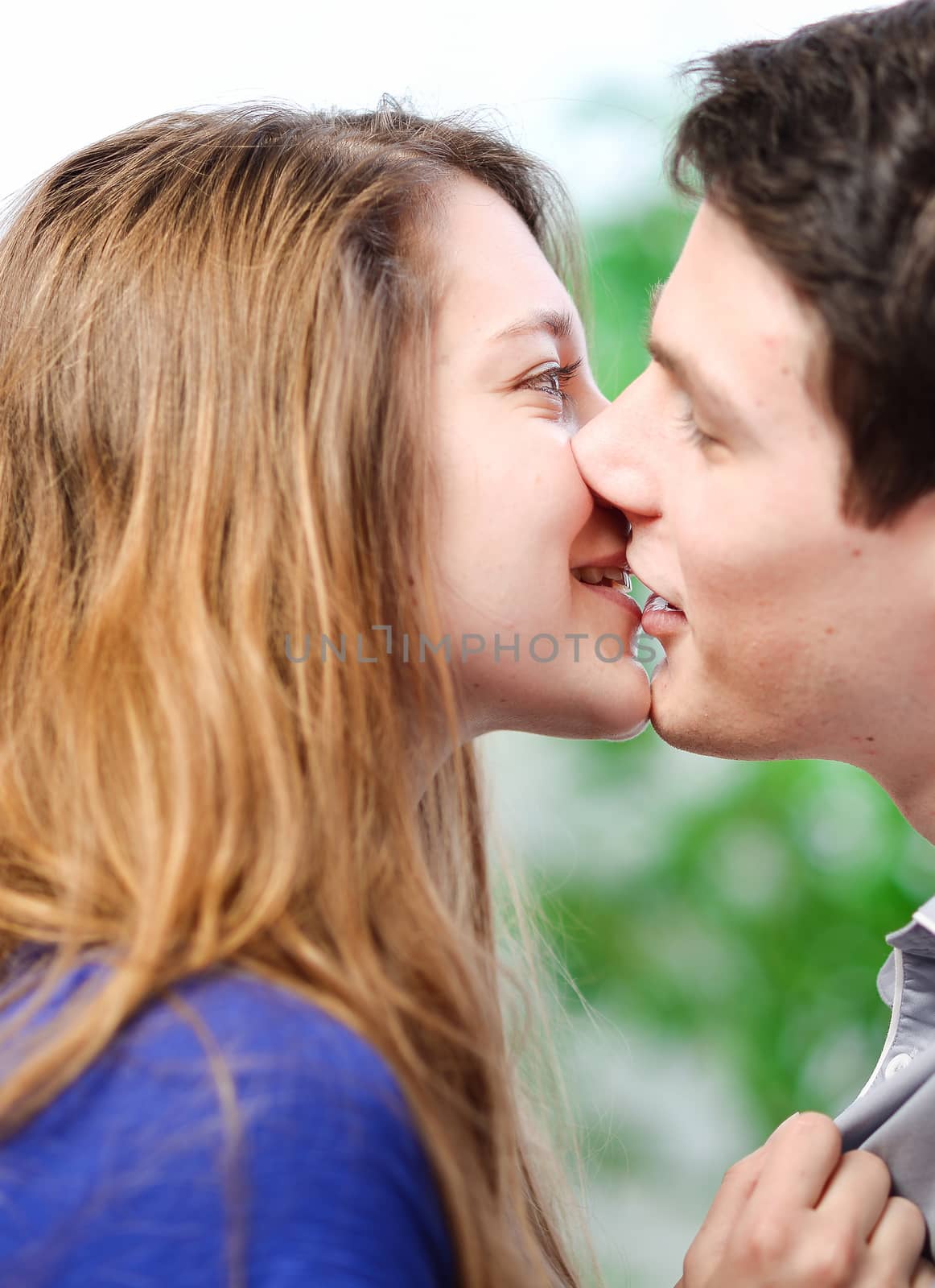 Attractive couple of lovers kissing itself lovingly on a sofa by pixinoo