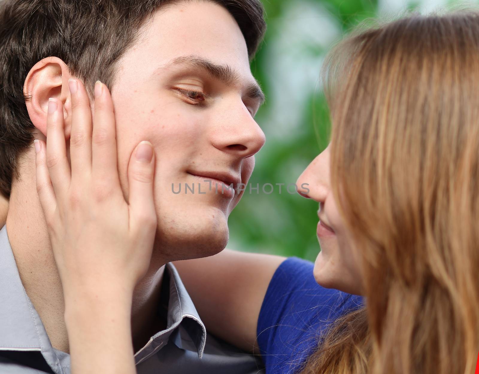 pretty woman stroking the cheek of her boyfriend with love by pixinoo
