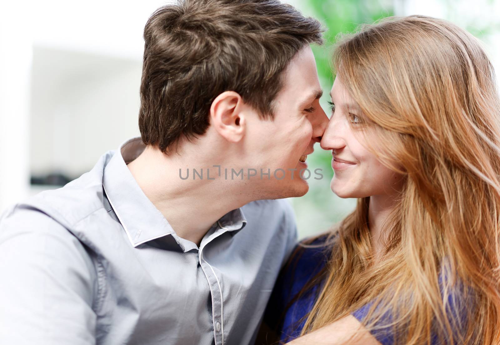 Very attractive young couple flirting on a sofa in living-room