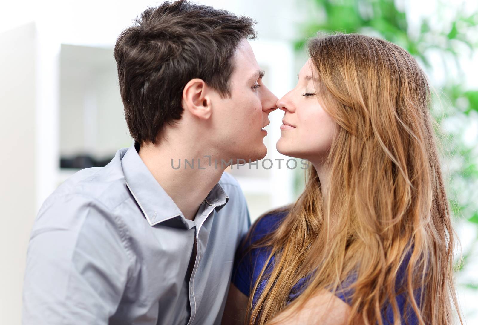 Very attractive young couple flirting on a sofa in living-room