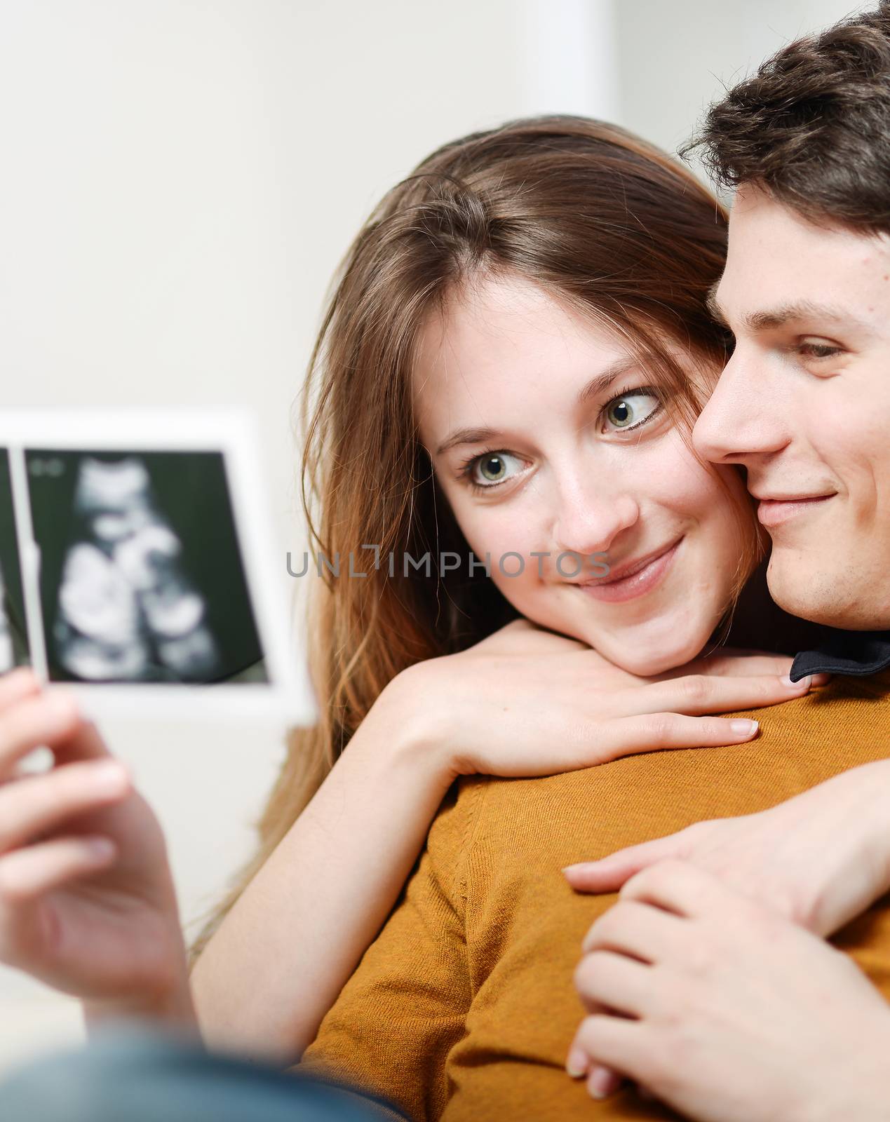 Beautiful couple watching with emotion ultrasound pictures of th by pixinoo