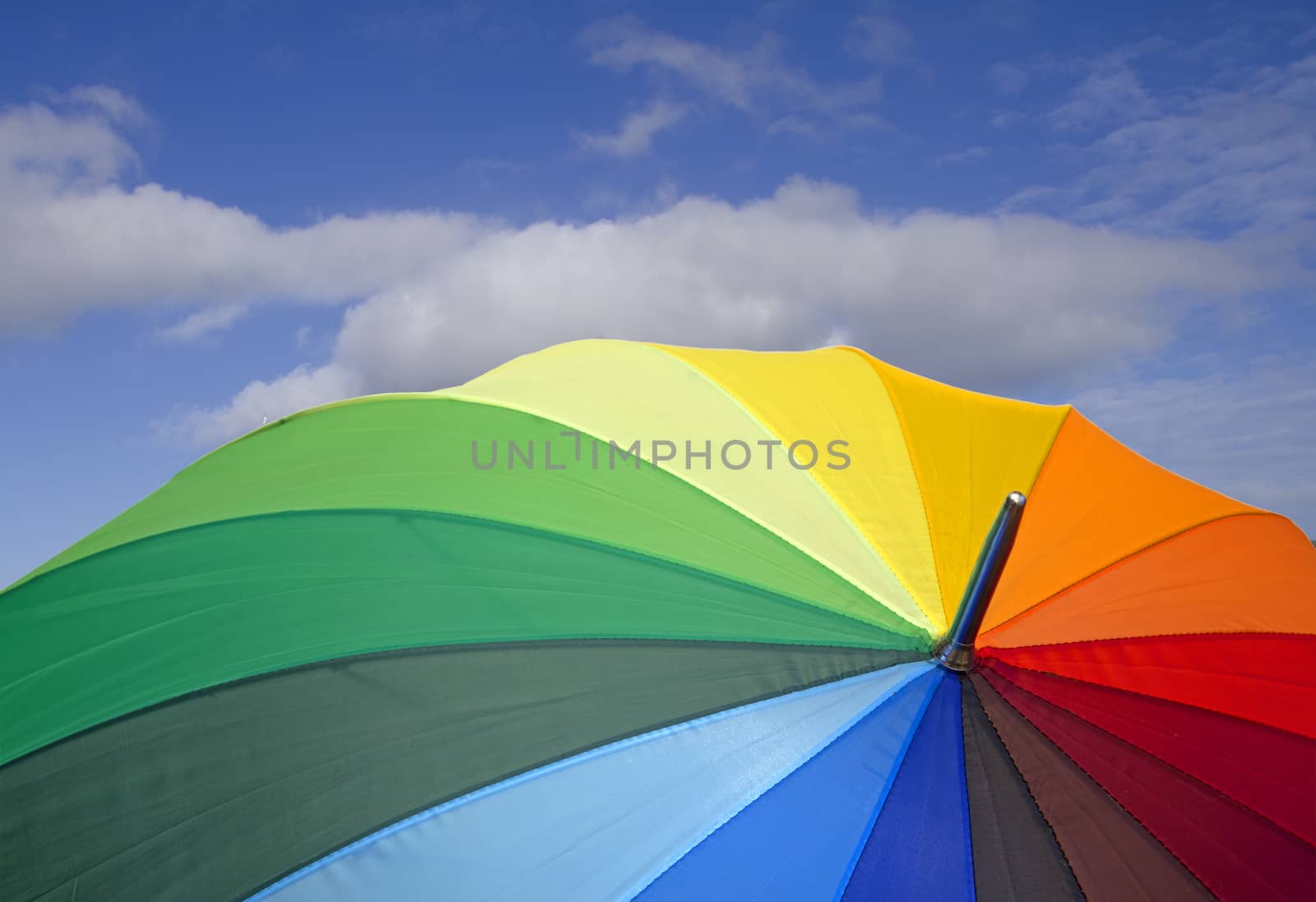 closeup of a colorful open umbrella over blue sky