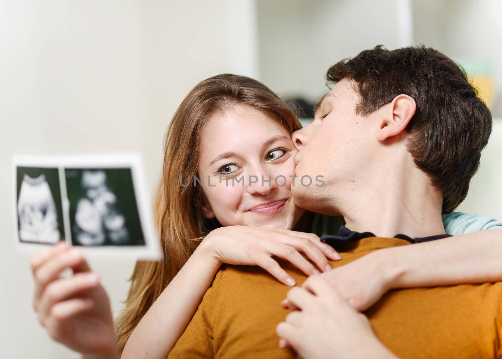Beautiful couple watching with emotion ultrasound pictures of th by pixinoo