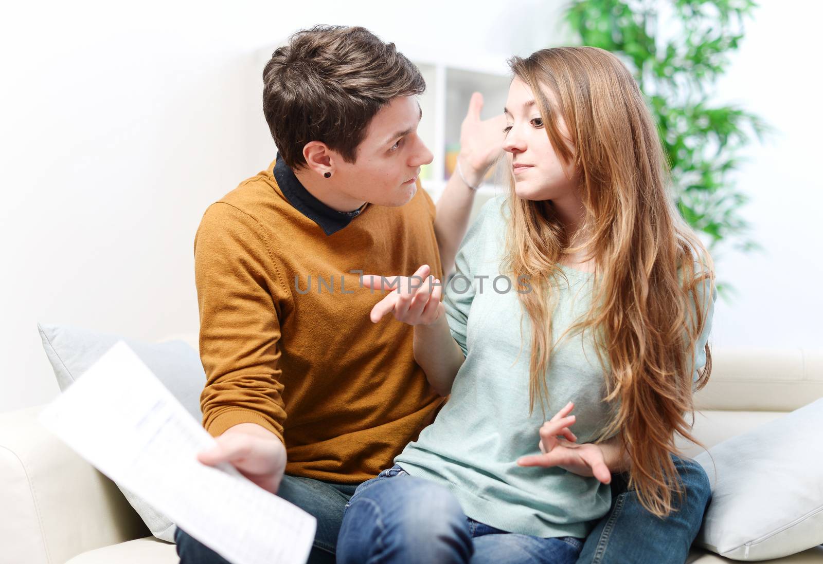 Young anxious couple quarrels by consulting their bank account