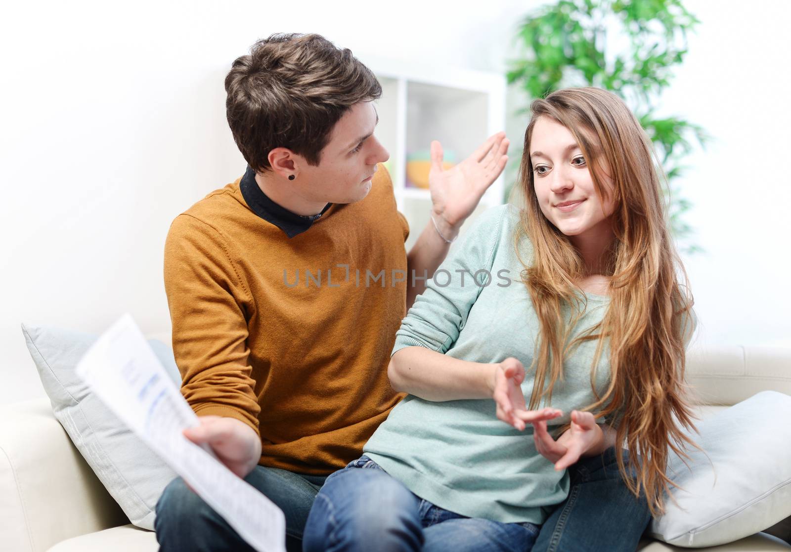 Young anxious couple quarrels by consulting their bank account