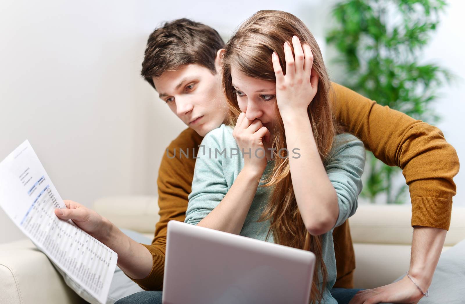 Young anxious couple consults their bank account