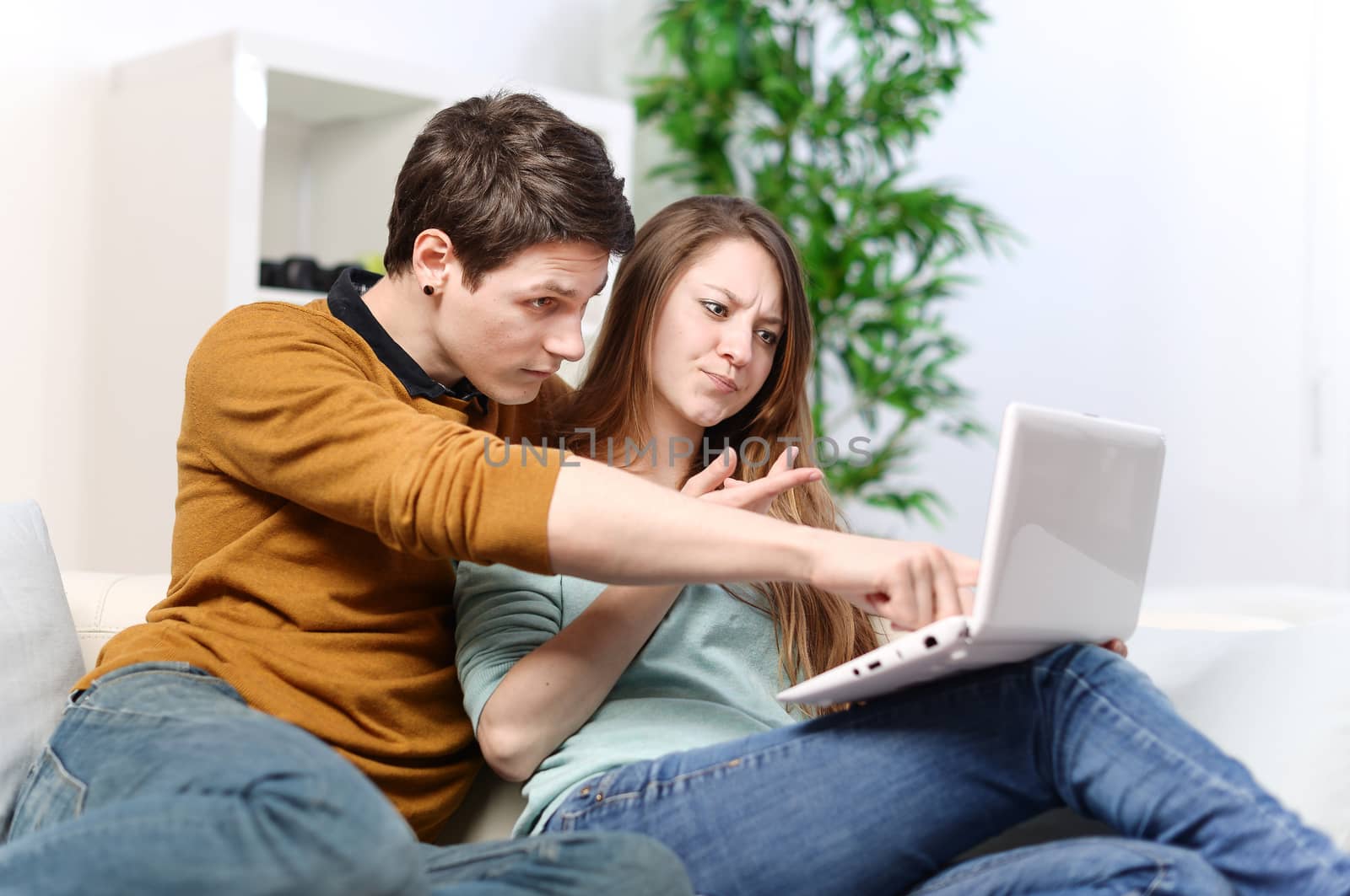 Couple of lovers uses a computer with a worried attitude