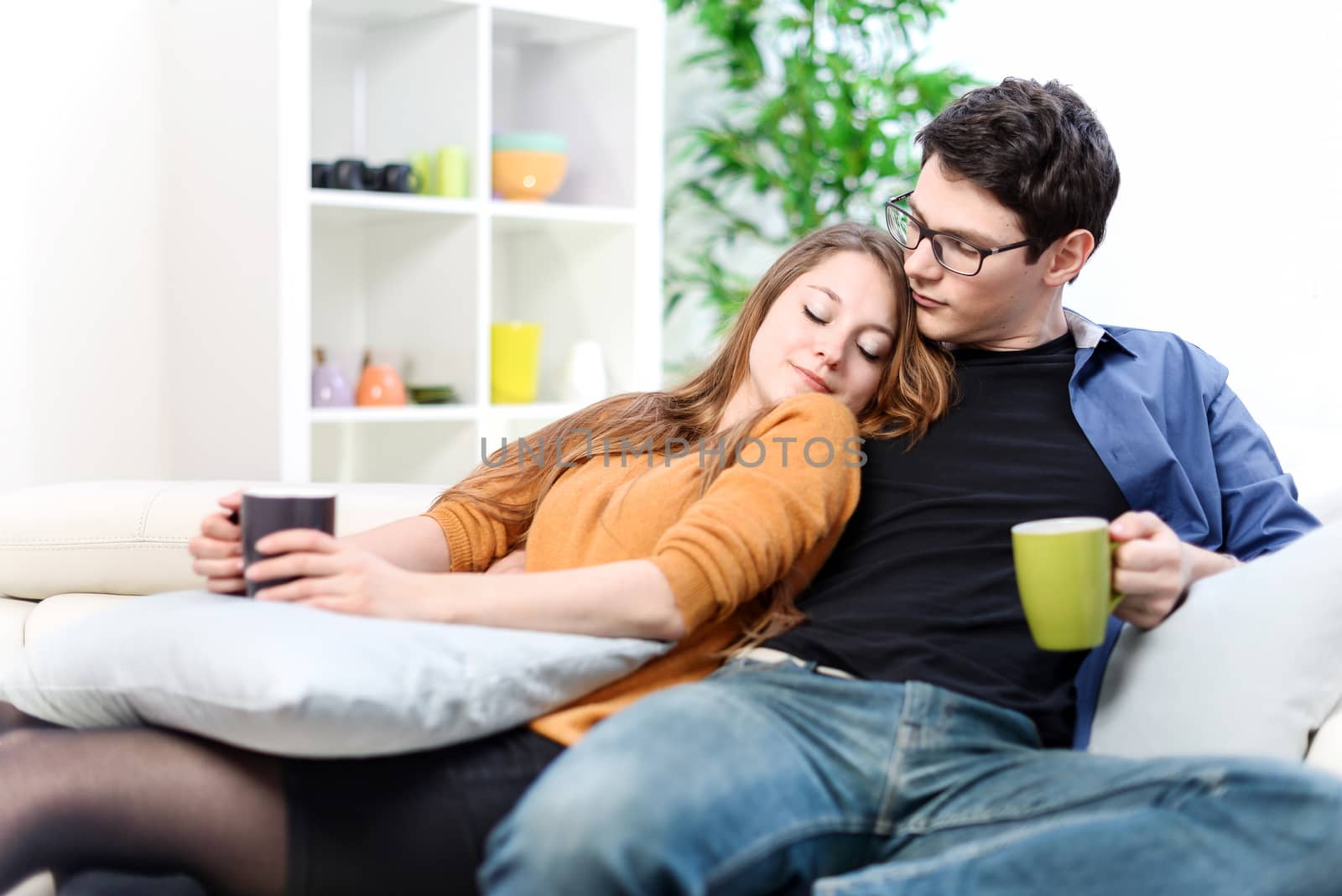 Cheerful couple relaxing together on sofa in living room