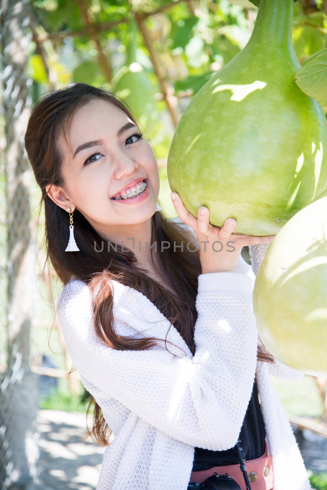 A smile of happy asian woman with calabash vegetable by jakgree