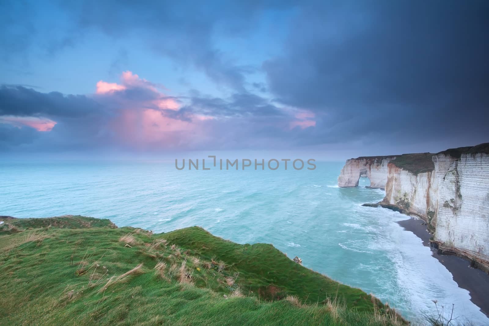 beautiful sunrise over cliffs in Atlantic ocean, Etretat, France