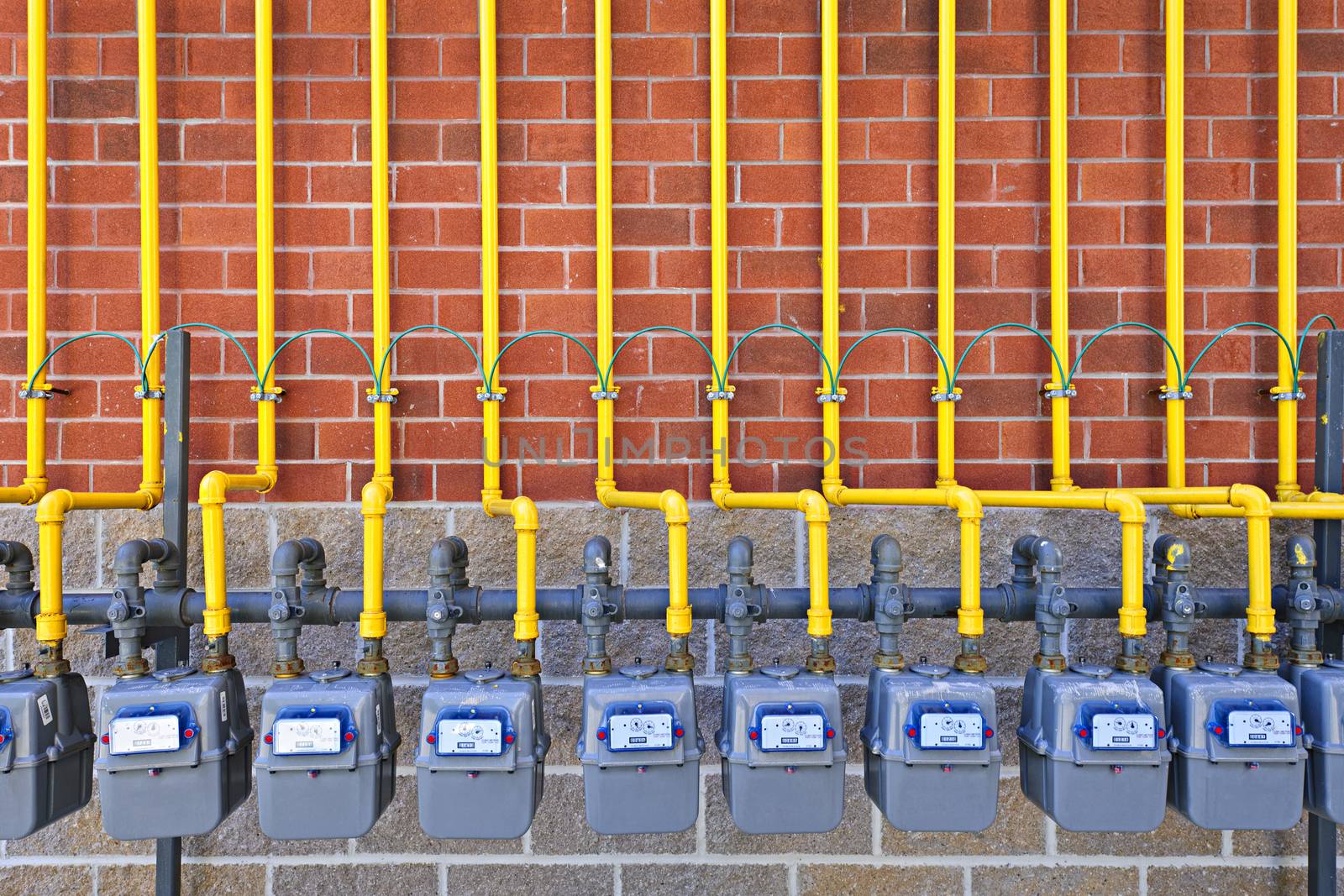 Gas meters on brick wall by elenathewise