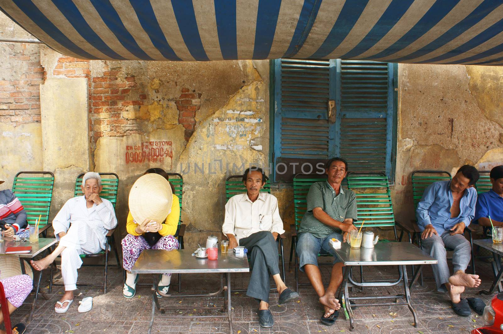SAI GON, VIET NAM- APRIL 12: People sitting in make shift shop coffee on pavement to have breakfast, this is specific habit of Vietnamese  Viet Nam on April 12, 2013