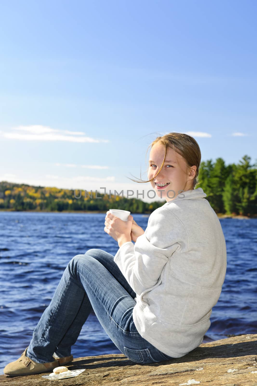 Young woman relaxing at lake shore by elenathewise