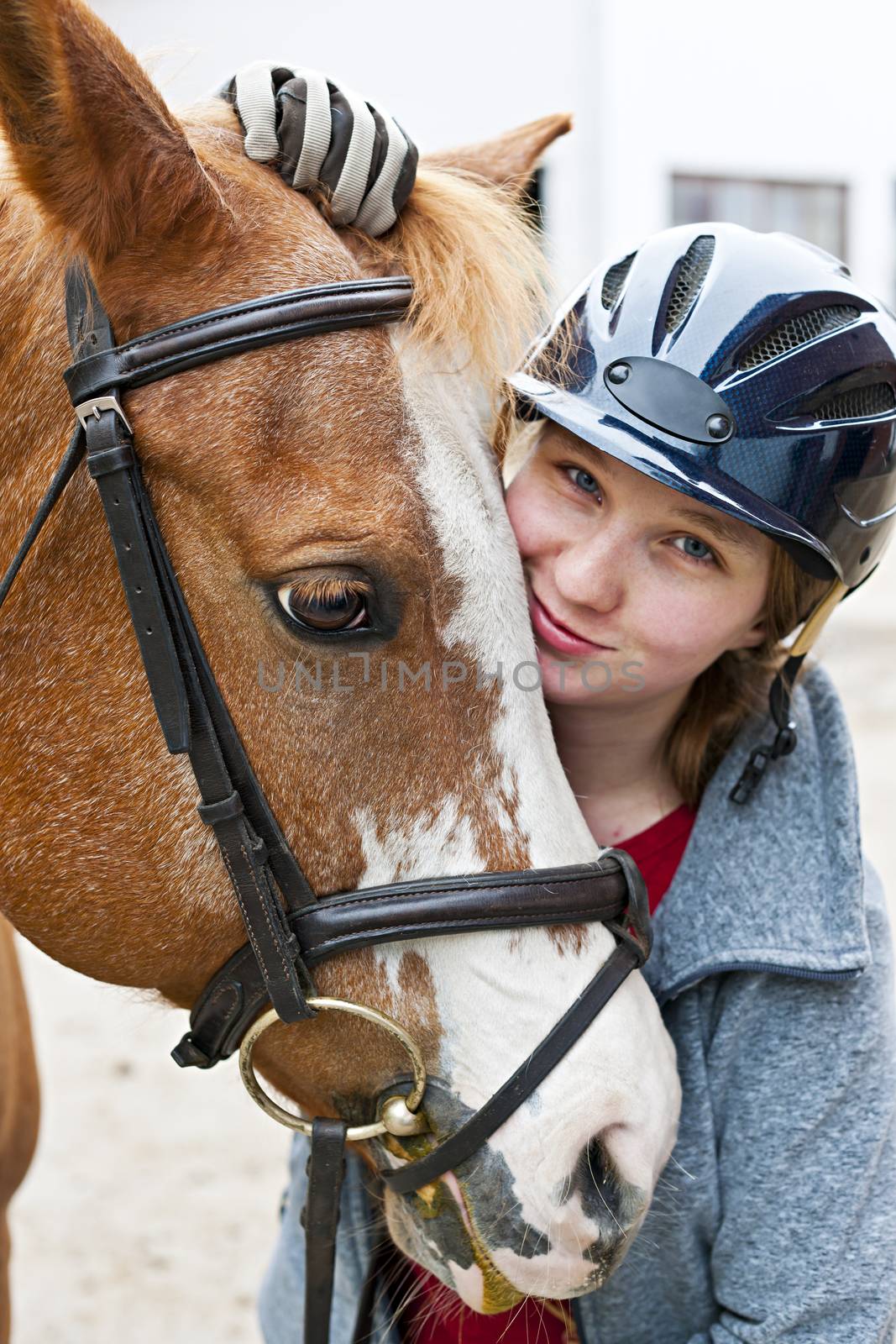 Portrait of young woman rider with brown horse