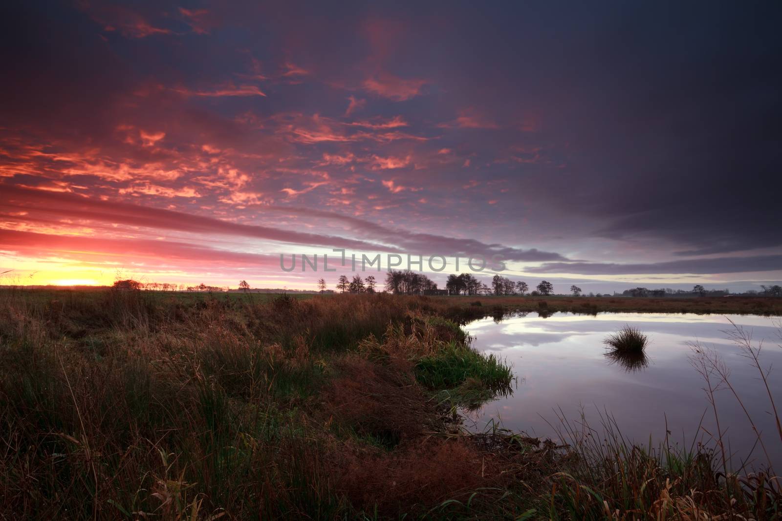 dramatic purple sunrise over river, Drenthe, Netherlands