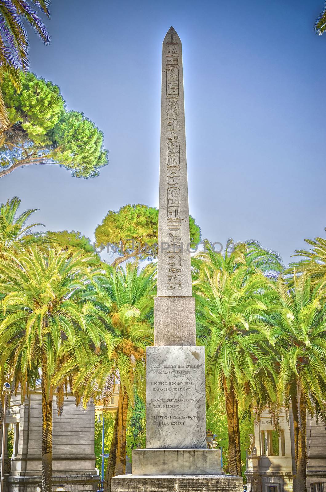 Ancient Obelisk surrounded by palms on a sunny day