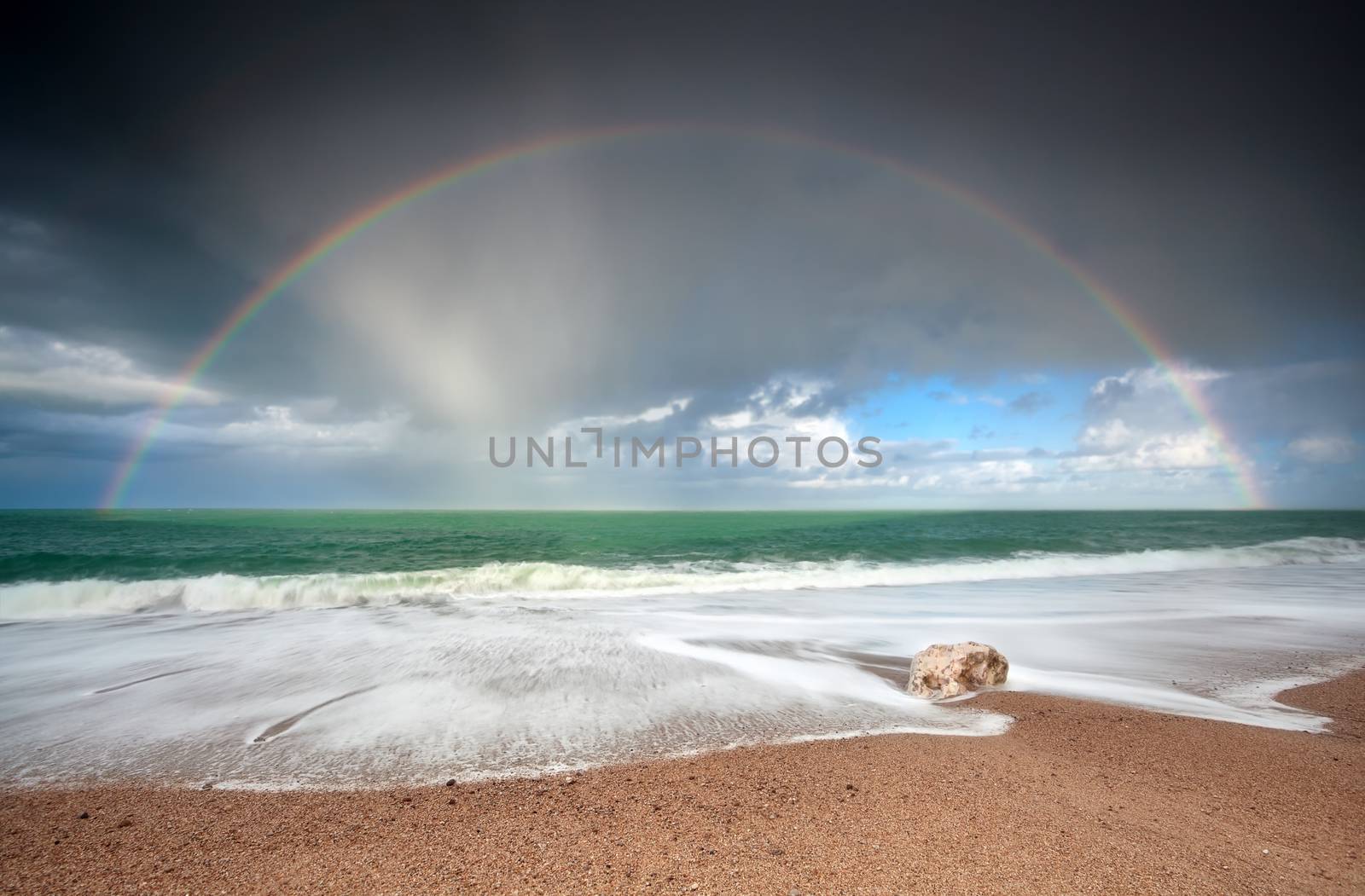 rainbow over Atlantic ocean waves on coast, Etretat, France