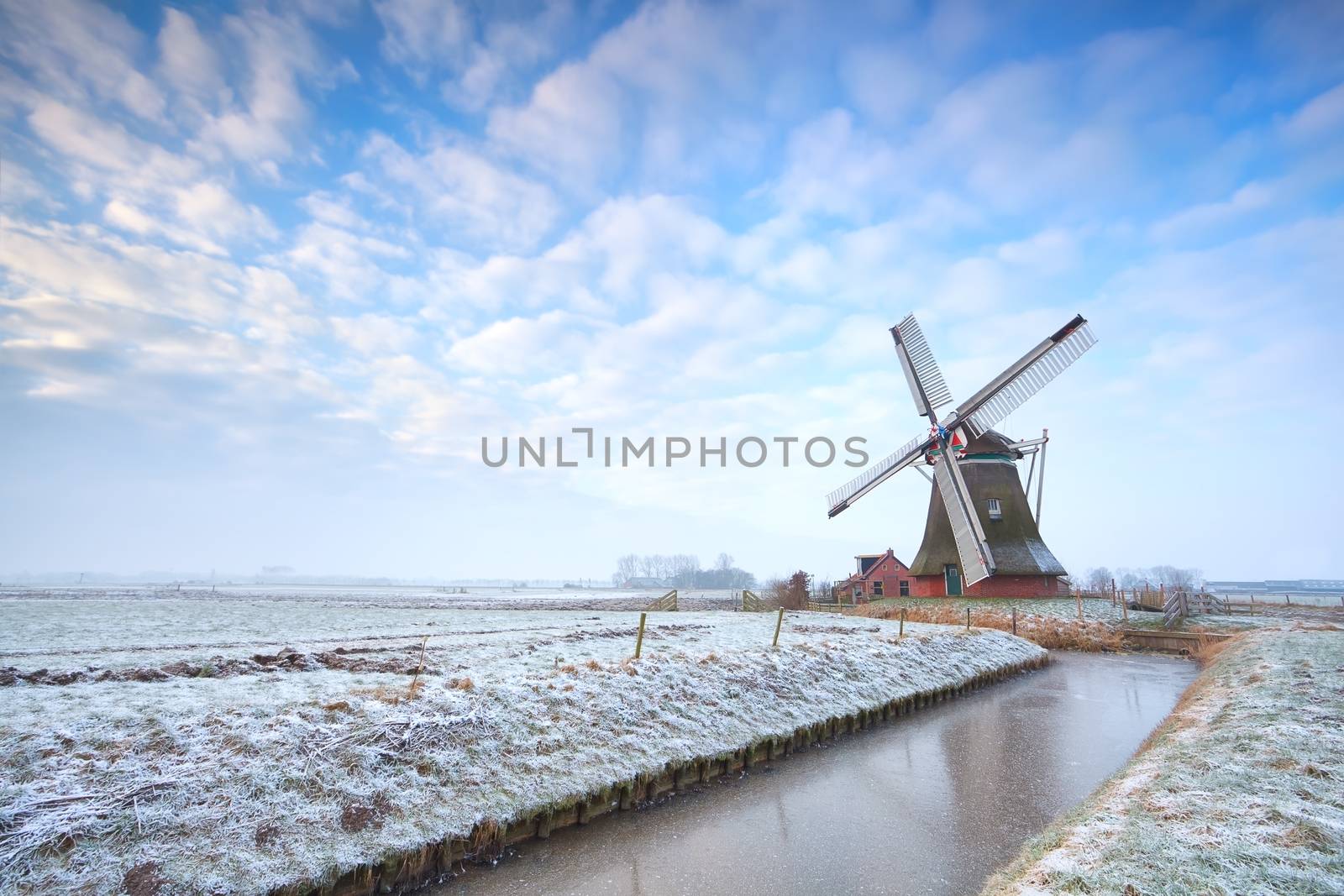 Dutch windmill in winter over blue sky, Holland