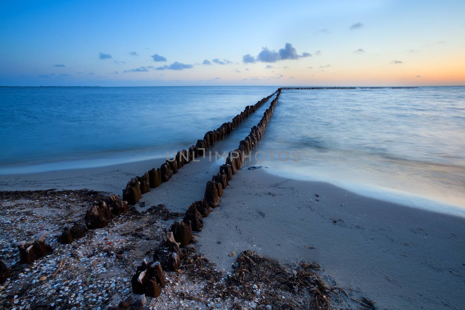 long wooden breakwater in North sea during sunset, Hindeloopen, Netherlands