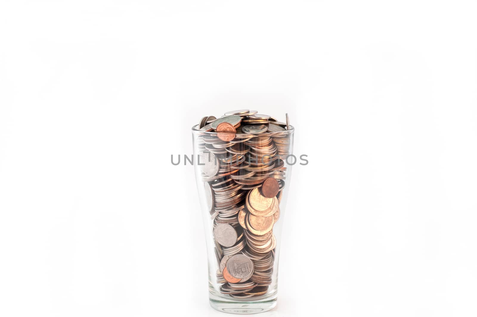 Coins in a glass of water on white background