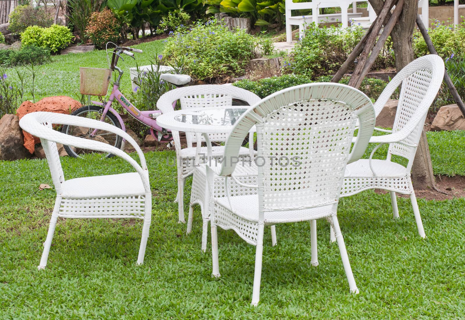 White table and chairs in beautiful garden.