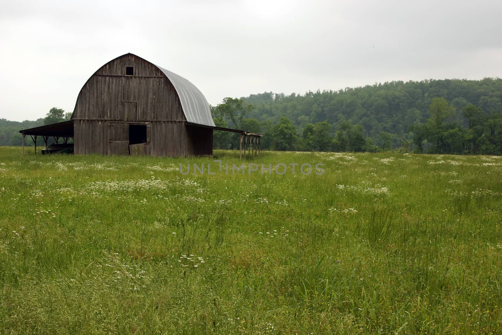 A brown barn in a field found out in the country