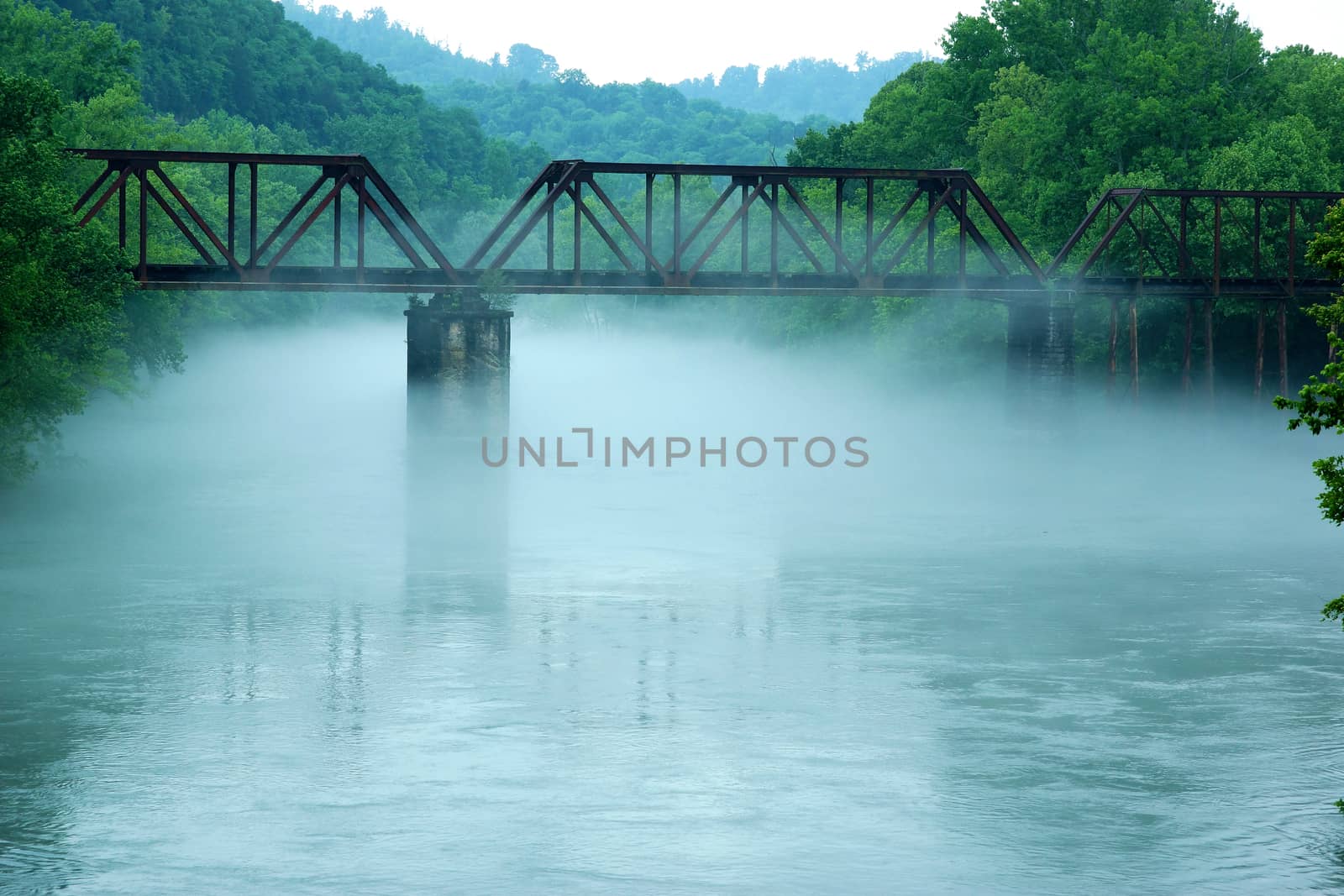 Railroad train tracks over a bridge in the fog