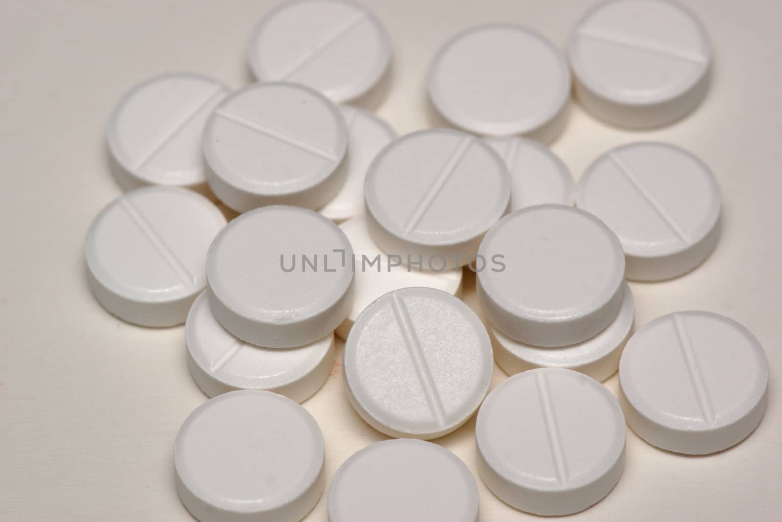 A group of white round circulare tablets containing medicine