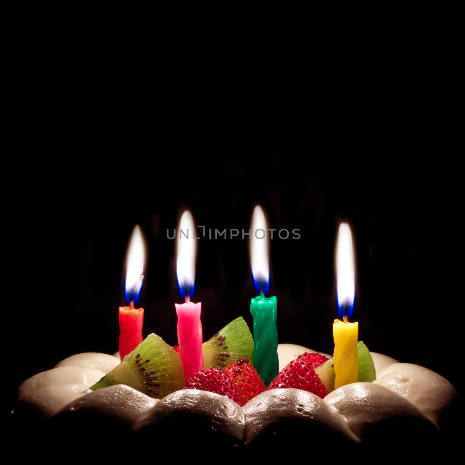 Birthday cake on a black background with candles light 
