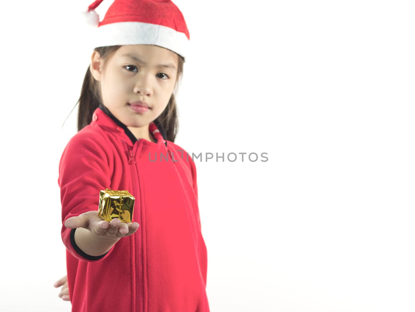 Little girl in the santa claus hat, holding a gift box in hand