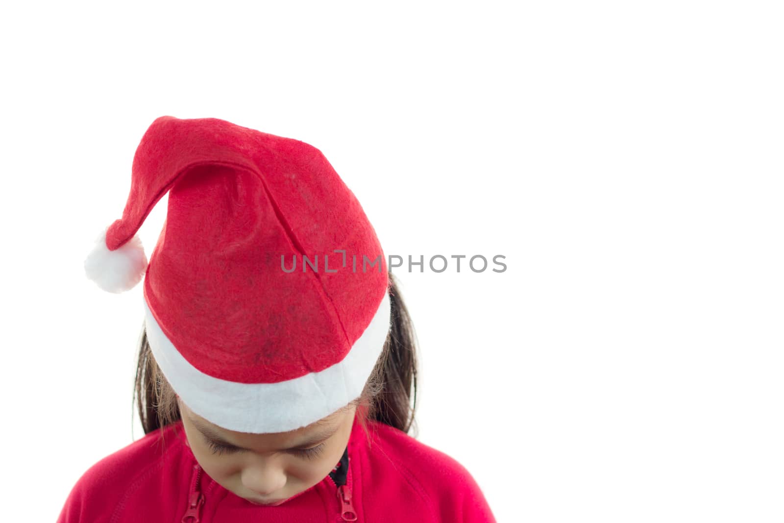 Little girl in the santa claus hat, feeling so sad