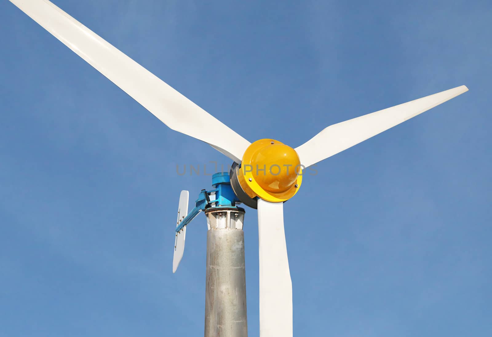 Close-up of wind turbine with blue sky