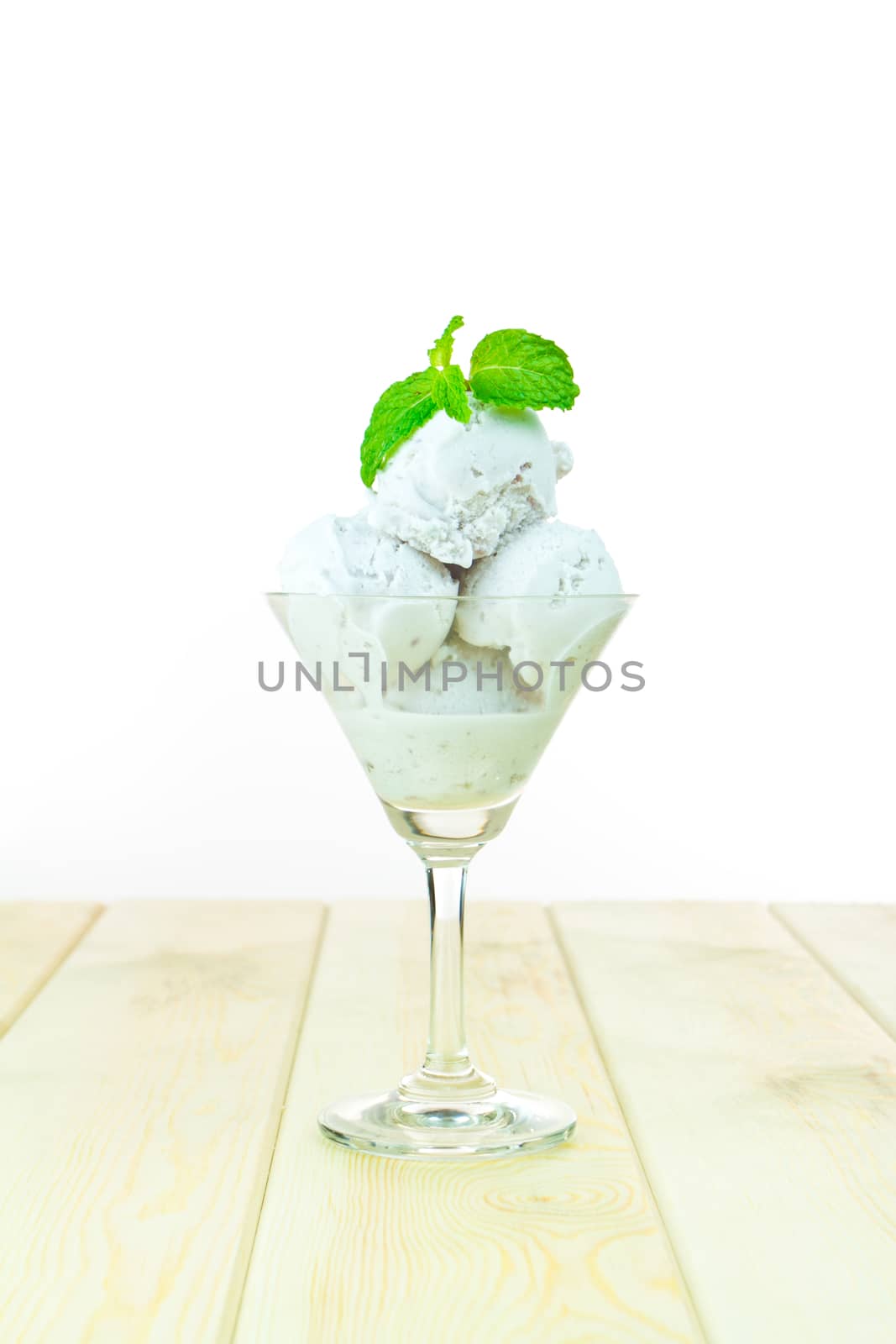 Coconut ice cream with mint in cup on wood 