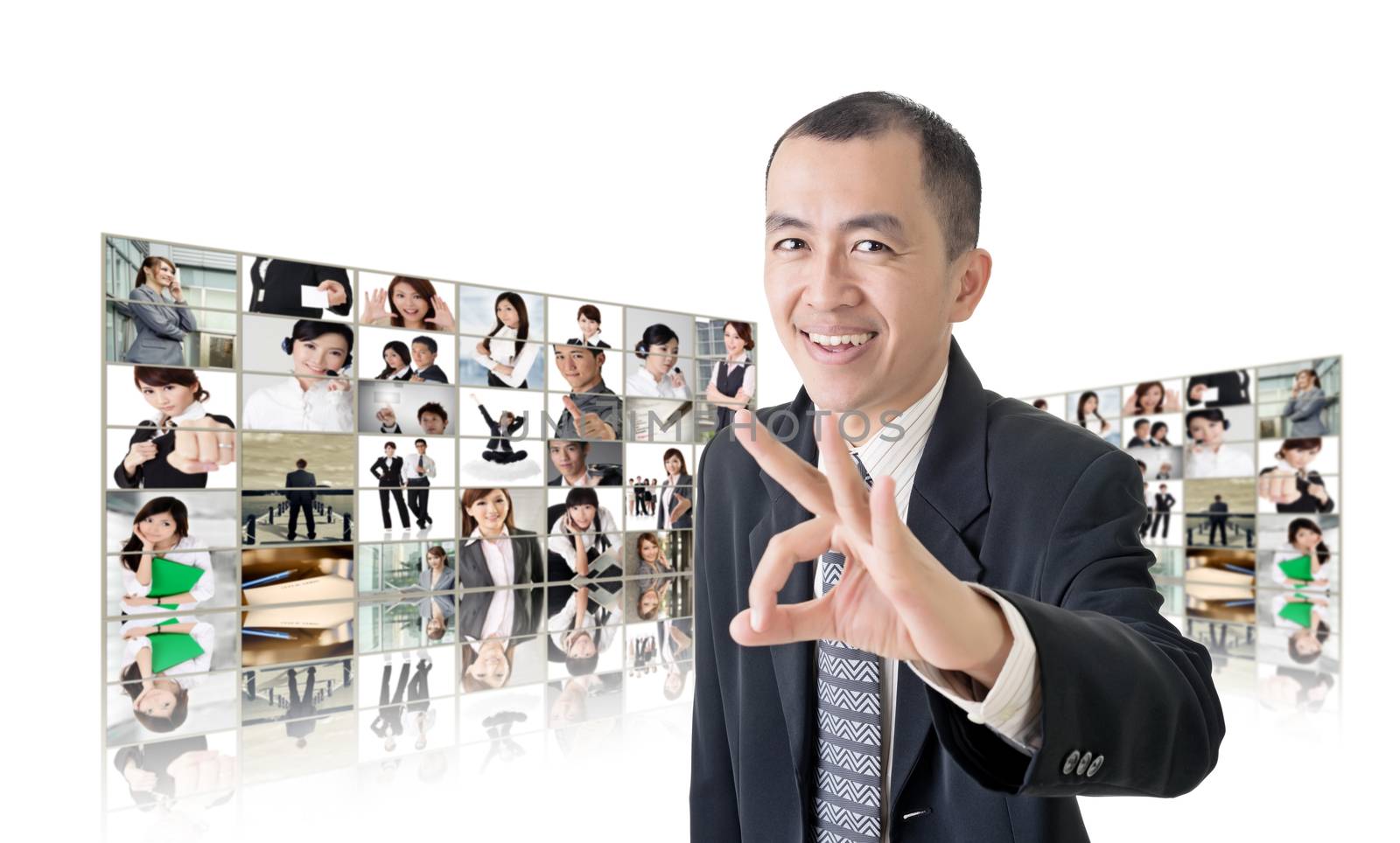 Asian business man or boss standing in front of tV screen wall showing pictures of business concept.