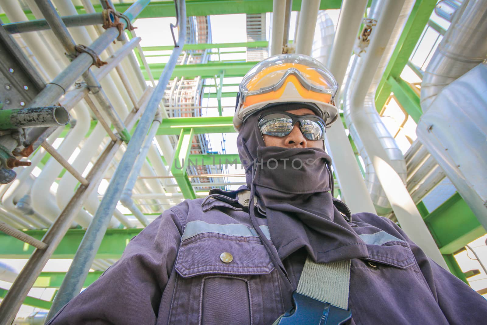 Man with safety personal protection equipment in industrial plant background 