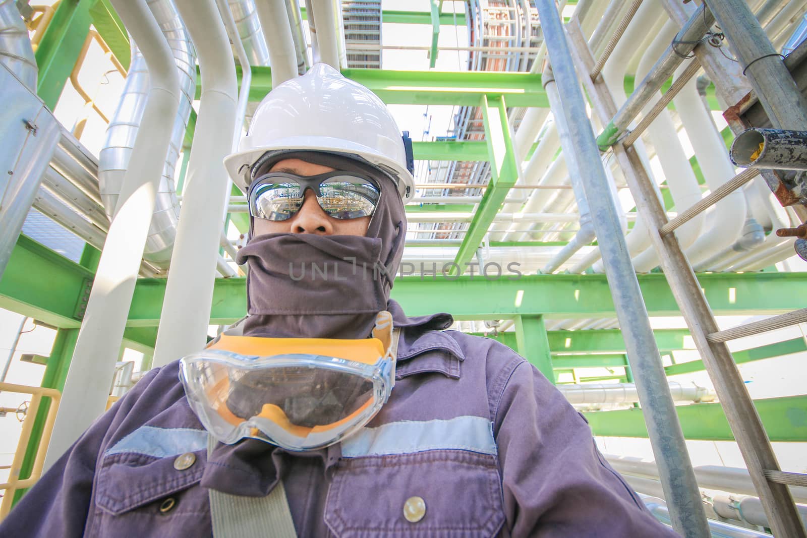 Man with safety personal protection equipment in industrial plant background 