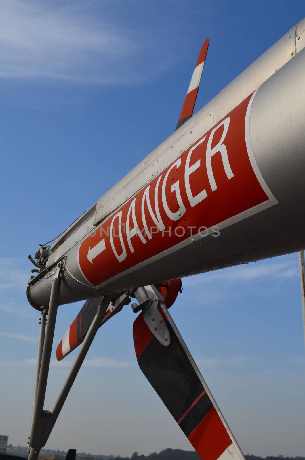 Military helicopters tail rotor blades showing danger warning sign.