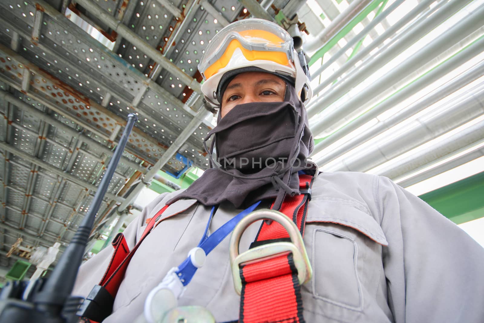 Man with safety personal protection equipment in industrial plant background 