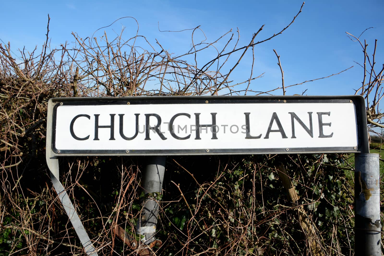Road sign for Church Lane, a common street name, against a rural hedgerow