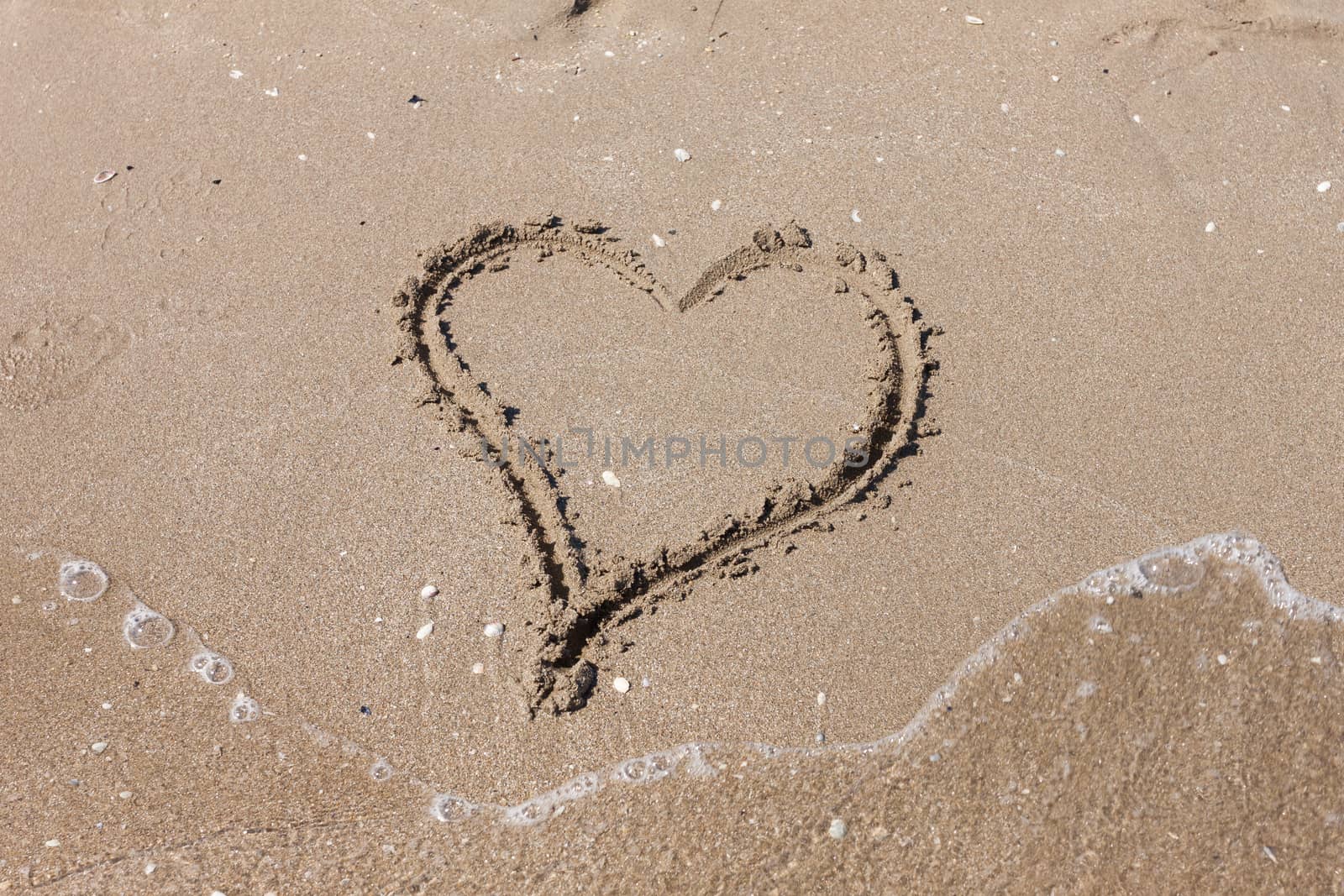 Heart on the sandy beach. Romantic composition.