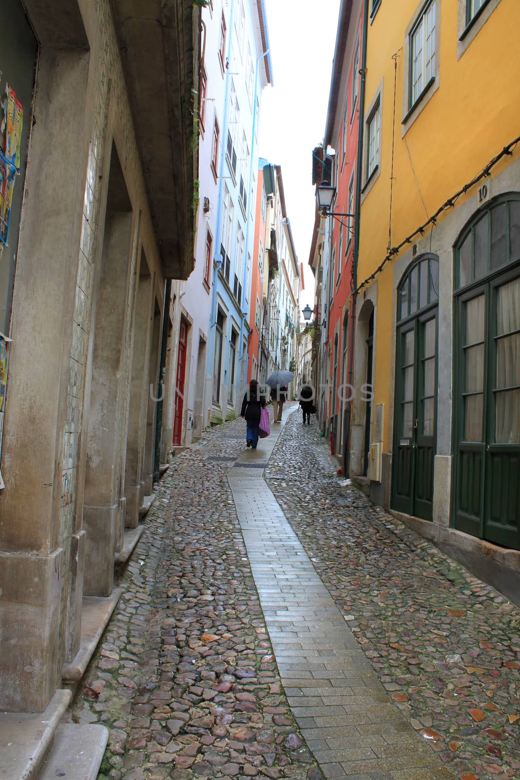 Going uphill on a cobblestone street in Coimbra, Portugal on a rainy day