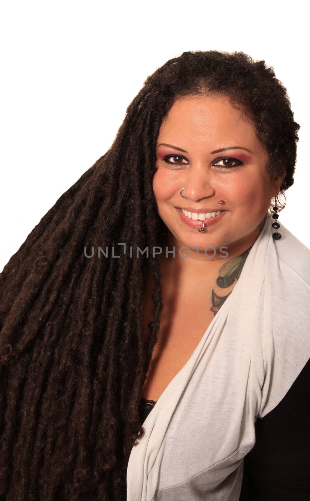 Beautiful ethnic curvaceous woman with long dreadlocks, tattoos and piercings, on a white background
