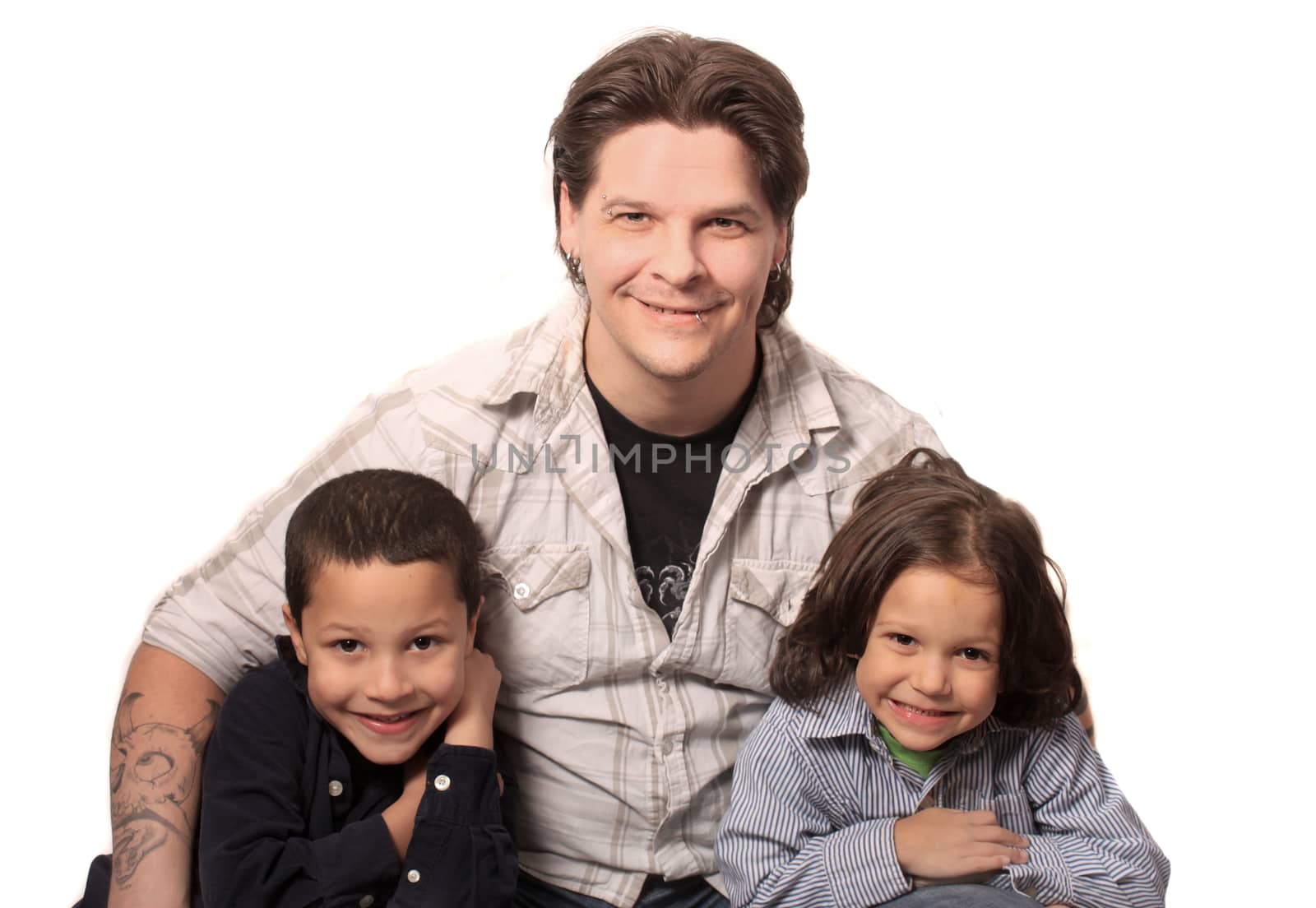 Tattoed and pierced father sitting with his two sons on a white background