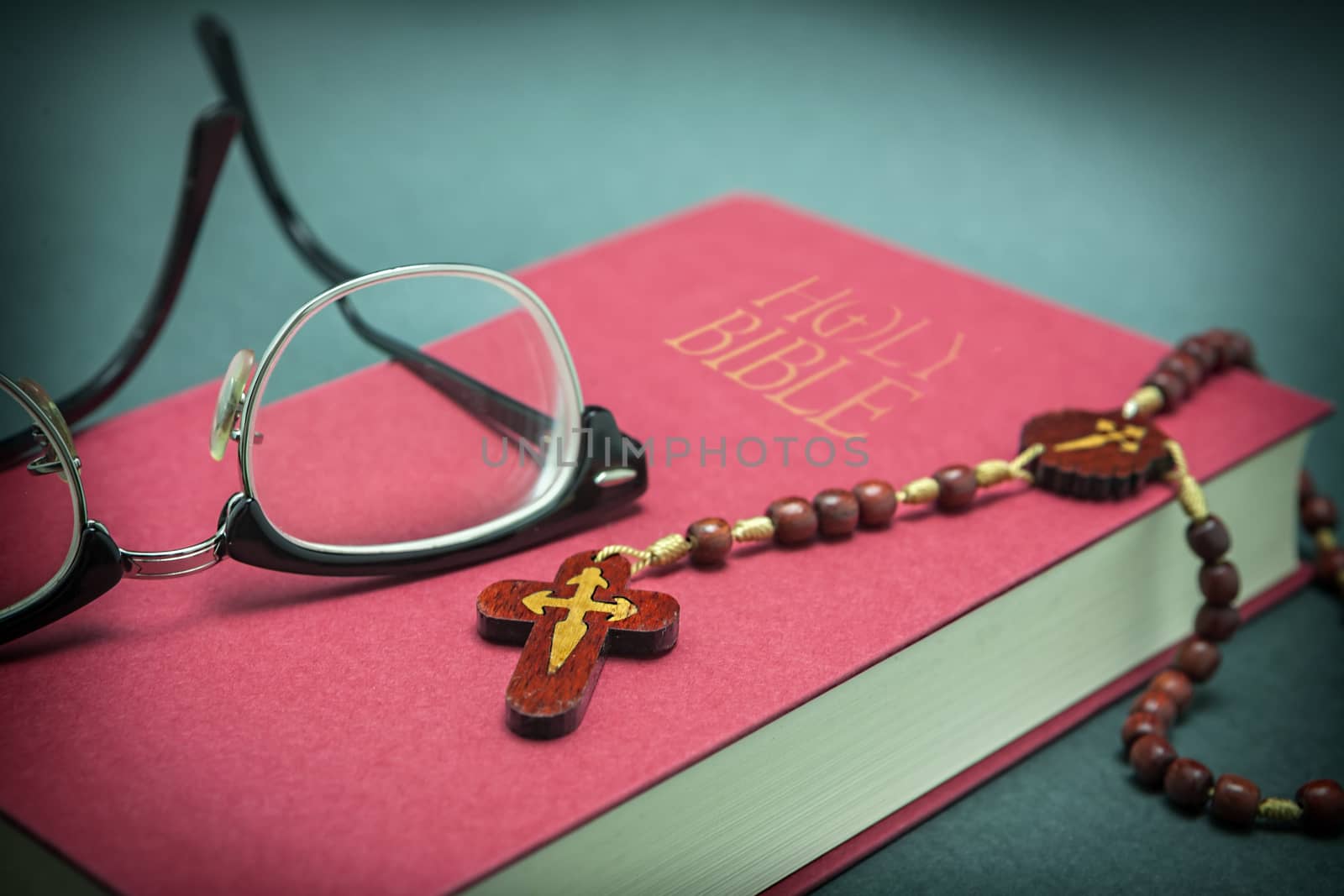 Glasses adjusted on the holy bible and beads