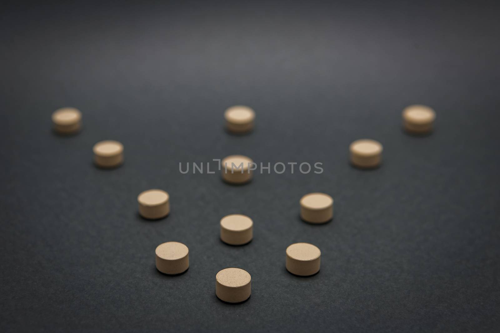 Some pills aligned in the form of flecla isolated on black background