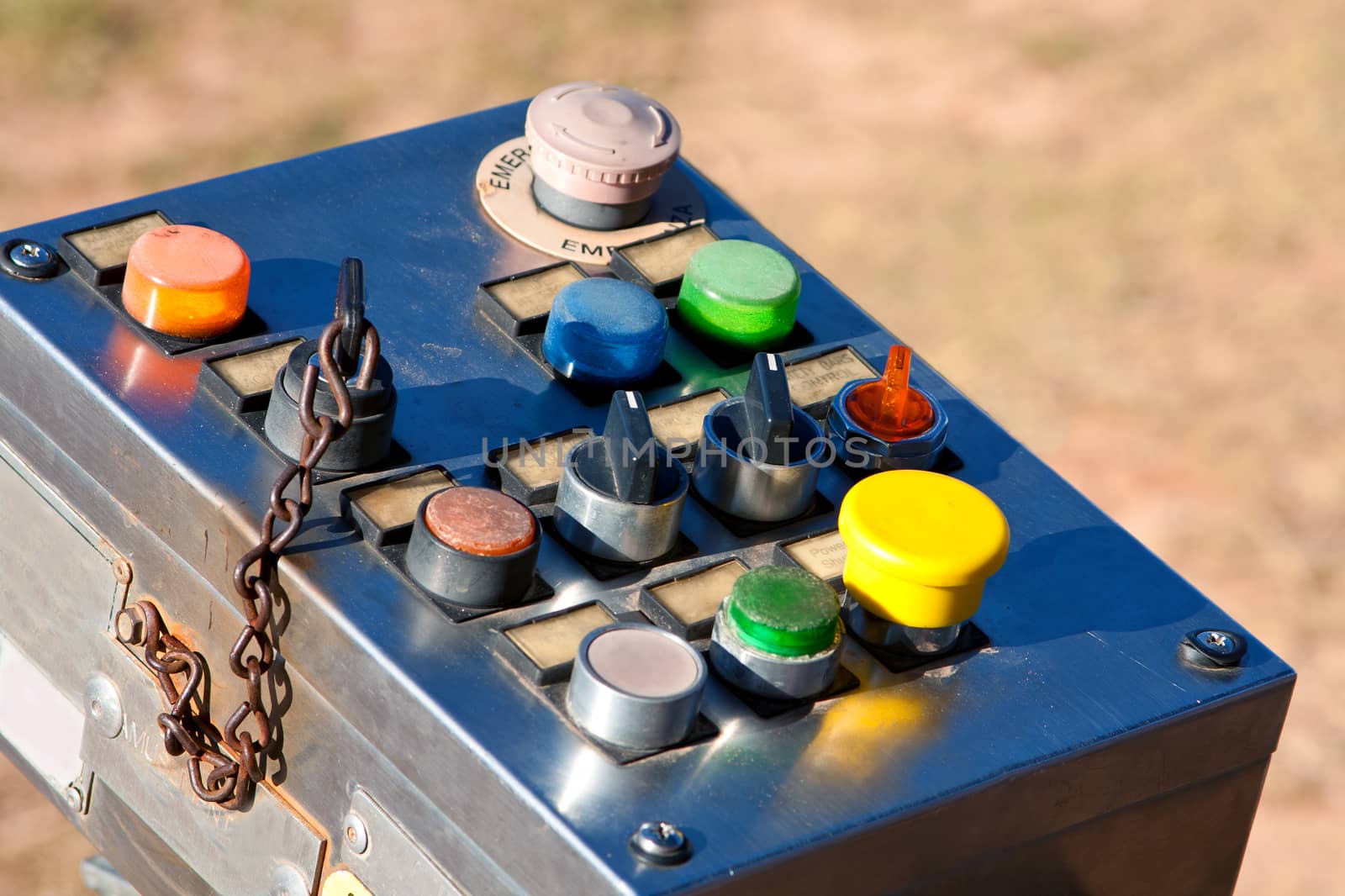 An old-fashioned industrial control panel with multi-colored buttons and switches, used to control a ride at a county fair.