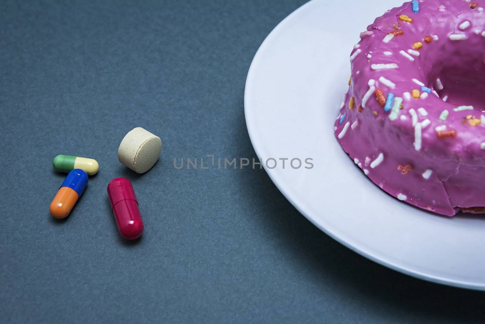 Various medicines to combat diabetes along with a sweet cake, concept of disease of hyperglycemia or diabetes