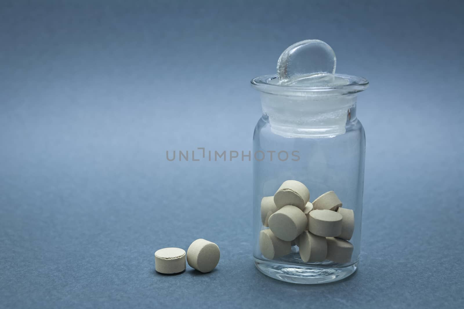 Old glass bottle with pads isolated on a blue background